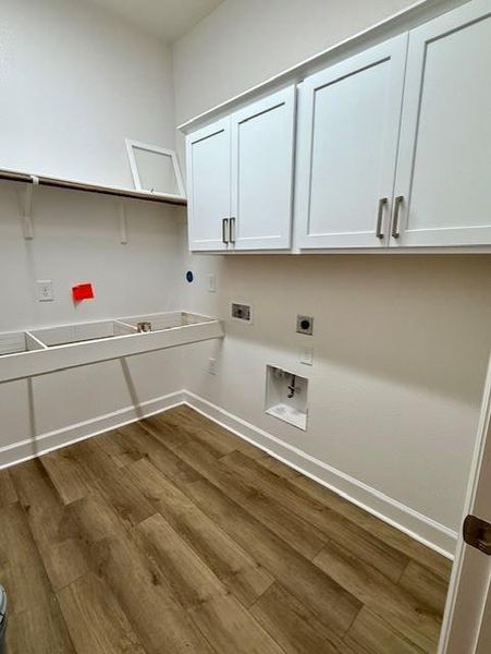 Spacious laundry room is plumbed for gas & electric, offers upper cabinets & folding table