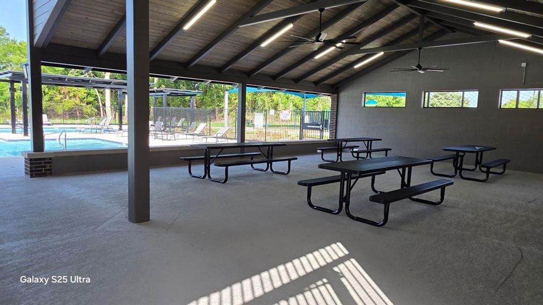 Spacious covered pavilion with a vaulted wood-finish ceiling, exposed beams, and ceiling fans Spacious covered pavilion with a vaulted wood-finish ceiling, exposed beams, and ceiling fans