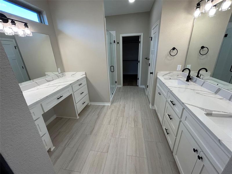 Bathroom with a stall shower, vanity, wood finish floors, and a spacious closet