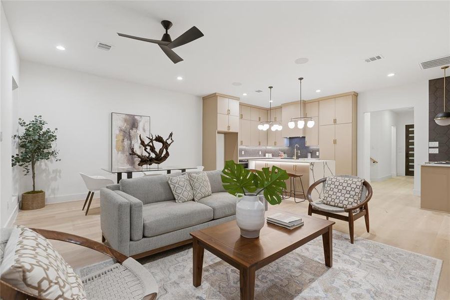 Open-concept living space featuring light wood-finish flooring, recessed lighting, and a modern ceiling fan
