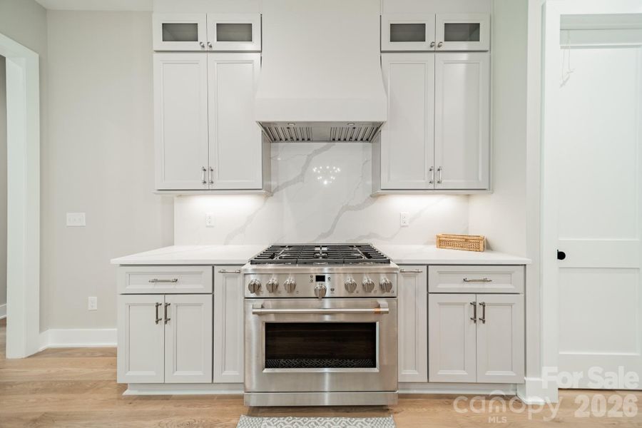 Fabulous Chef's Kitchen with oversized Gas Range and Oven, Quartz Counter Tops and Backsplash, and Custom Cabinetry