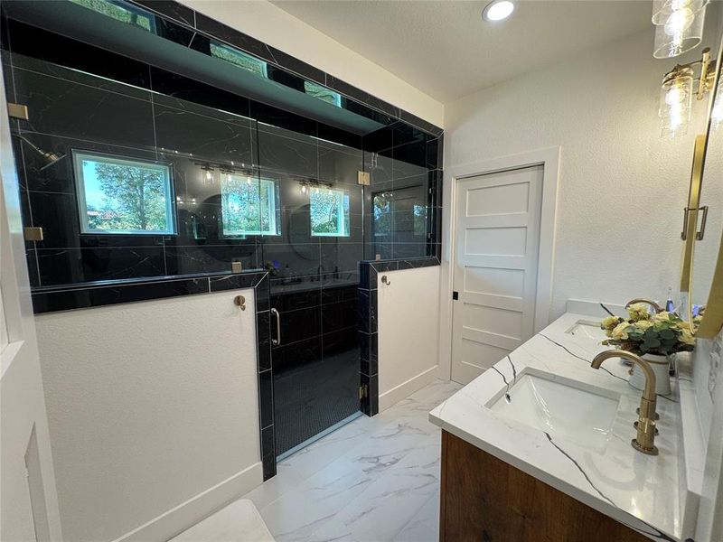 Master Bathroom featuring a shower stall, double vanity, light marble finish floors, a textured wall, and recessed lighting Master Bathroom featuring a shower stall, double vanity, light marble finish floors, a textured wall, and recessed lighting