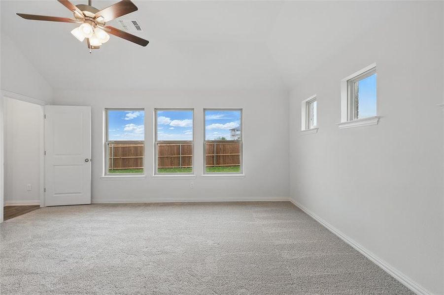 Empty room with visible vents, carpet, and vaulted ceiling Empty room with visible vents, carpet, and vaulted ceiling
