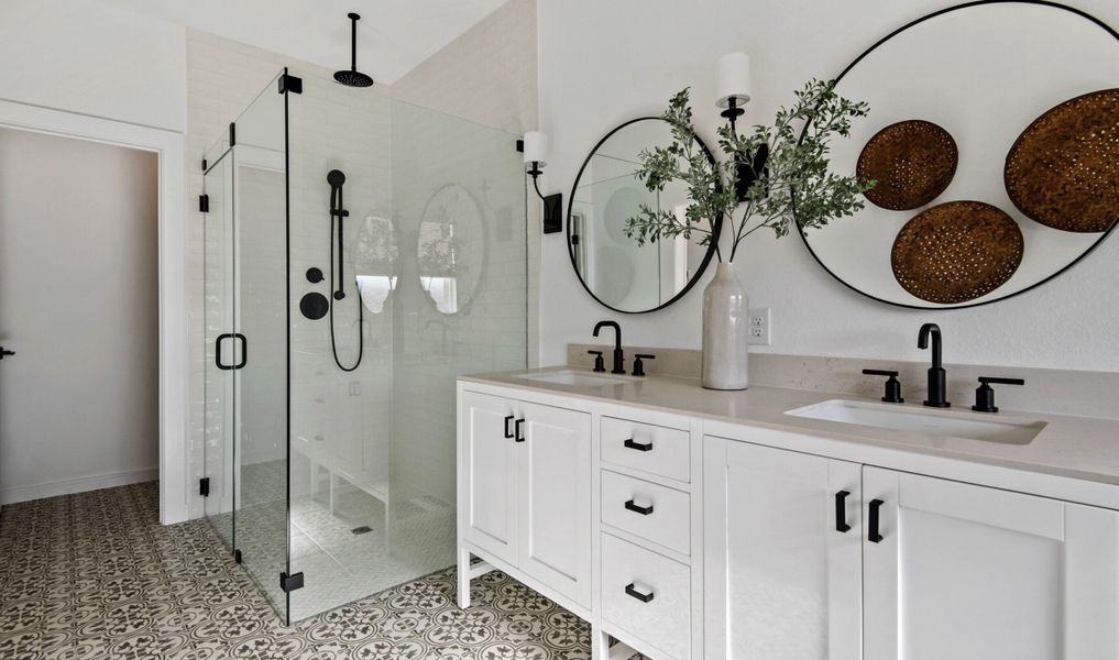 Primary bath with freestanding vanity and glass shower enclosure Primary bath with freestanding vanity and glass shower enclosure