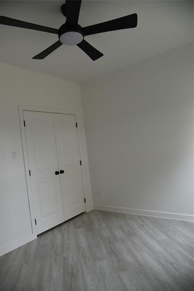 Unfurnished bedroom with ceiling fan, light hardwood / wood-style floors, and a closet