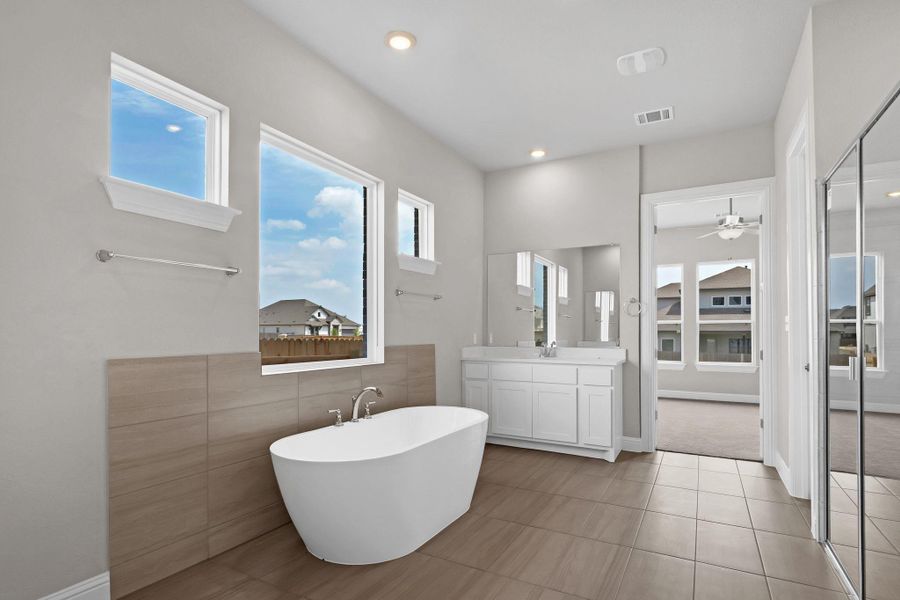 Full bath featuring a ceiling fan, a freestanding tub, vanity, visible vents, and recessed lighting Full bath featuring a ceiling fan, a freestanding tub, vanity, visible vents, and recessed lighting
