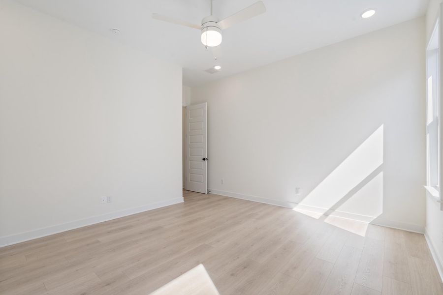 Room featuring wood-finish flooring, a neutral color palette, recessed lighting, and a ceiling-mounted light fixture with an integrated fan Room featuring wood-finish flooring, a neutral color palette, recessed lighting, and a ceiling-mounted light fixture with an integrated fan