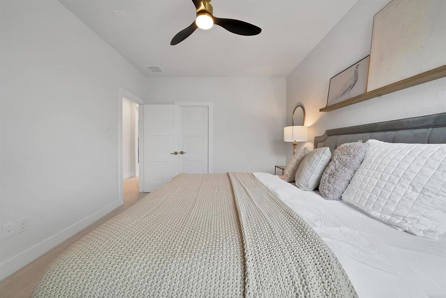 Gold-finish ceiling fan with black blades, light gray carpet flooring, white walls, and white trim Gold-finish ceiling fan with black blades, light gray carpet flooring, white walls, and white trim