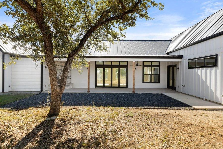 Back of property featuring a standing seam roof, a patio, and board and batten siding
