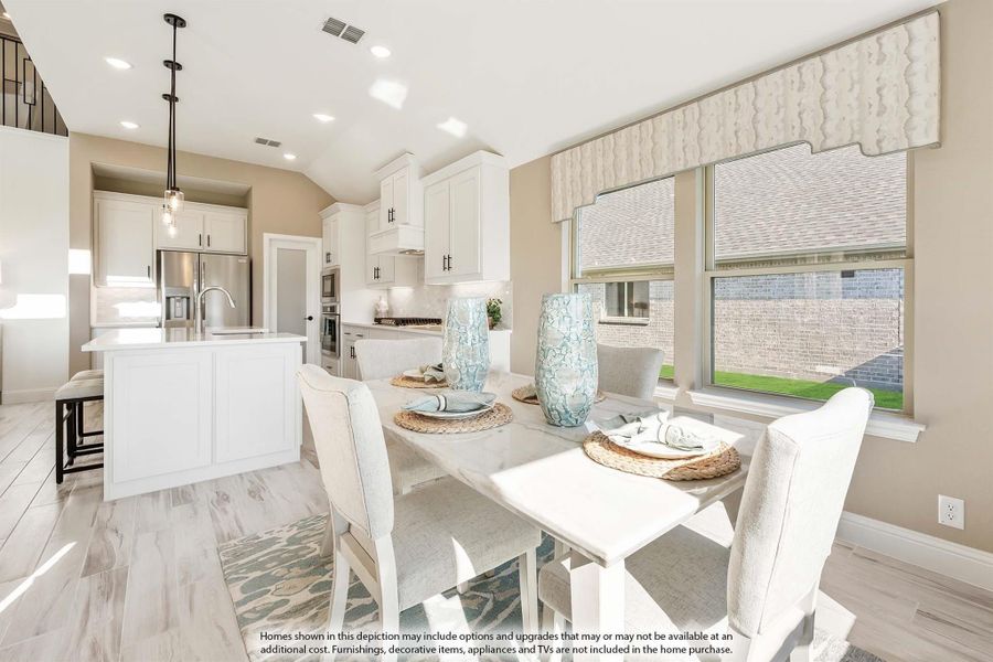 Dining area with white table and chairs open to kitchen with white cabinets and center island Dining area with white table and chairs open to kitchen with white cabinets and center island