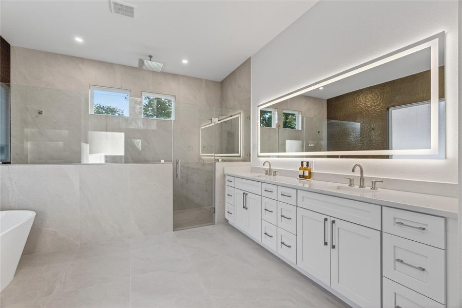 Another view of the primary bath highlights the spacious layout, freestanding tub, and beautifully finished shower. **Images are from a previously completed project. **