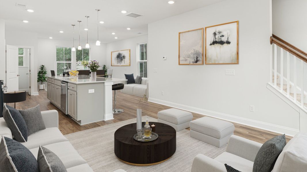 Living room with seating and island kitchen in a DRB Homes Brookgreen model