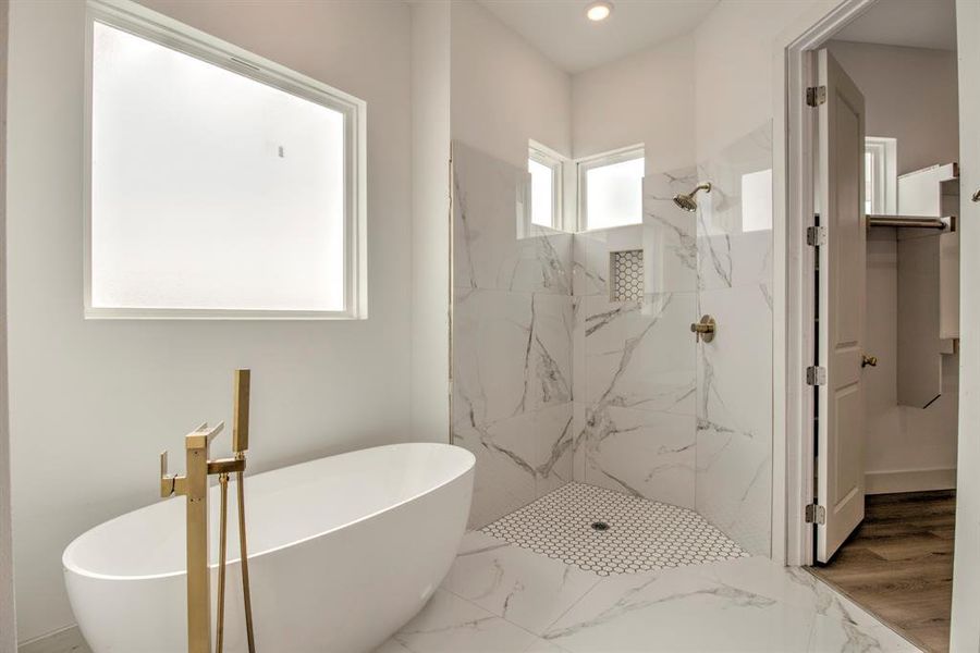 Full bathroom with a freestanding tub, a marble finish shower, marble finish floors, and recessed lighting Full bathroom with a freestanding tub, a marble finish shower, marble finish floors, and recessed lighting