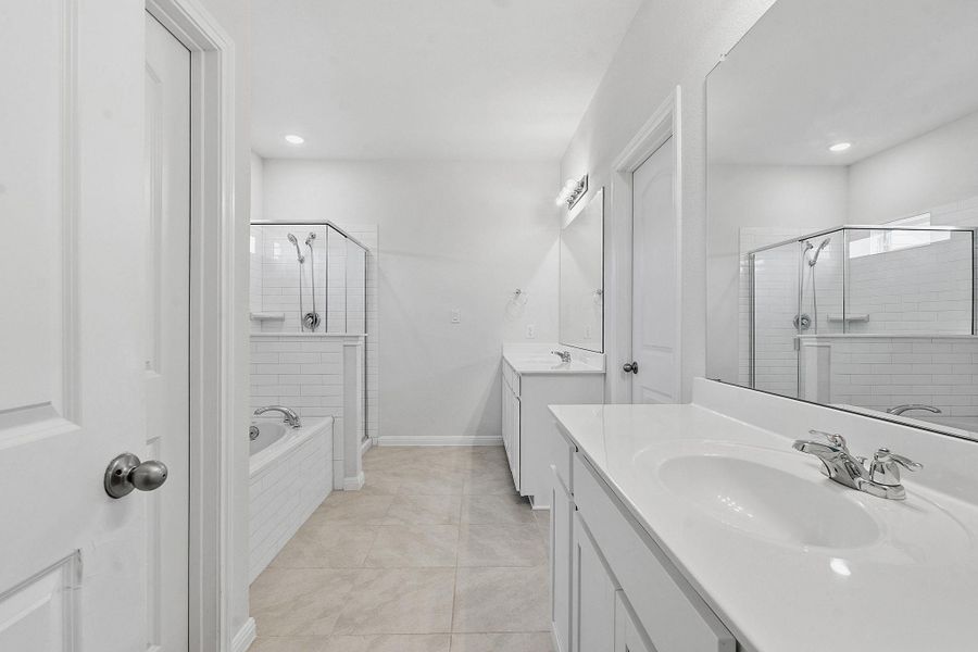 A well-appointed primary bathroom features dual vanities, a spacious walk-in shower, and a serene soaking tub. A well-appointed primary bathroom features dual vanities, a spacious walk-in shower, and a serene soaking tub.