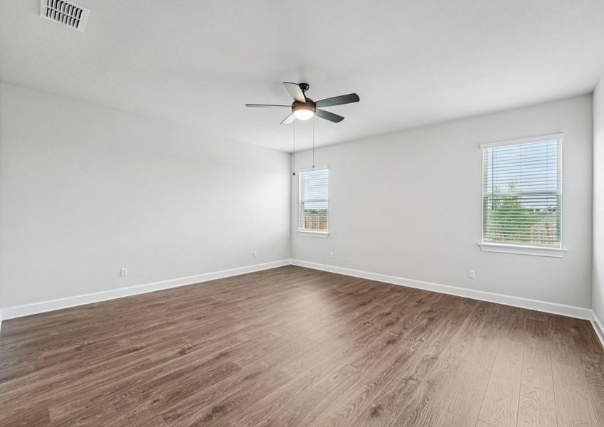 primary bedroom featuring a ceiling fan and wood-look vinyl flooring with natural light. primary bedroom featuring a ceiling fan and wood-look vinyl flooring with natural light.