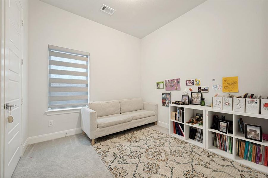 Carpeted room featuring a single window with blinds, white walls, and a modern door with paneling