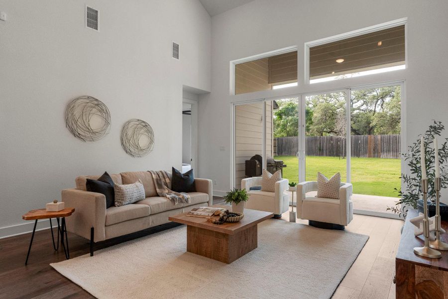 Floor-to-ceiling glass doors open to a generous, naturally illuminated living space with high ceilings.