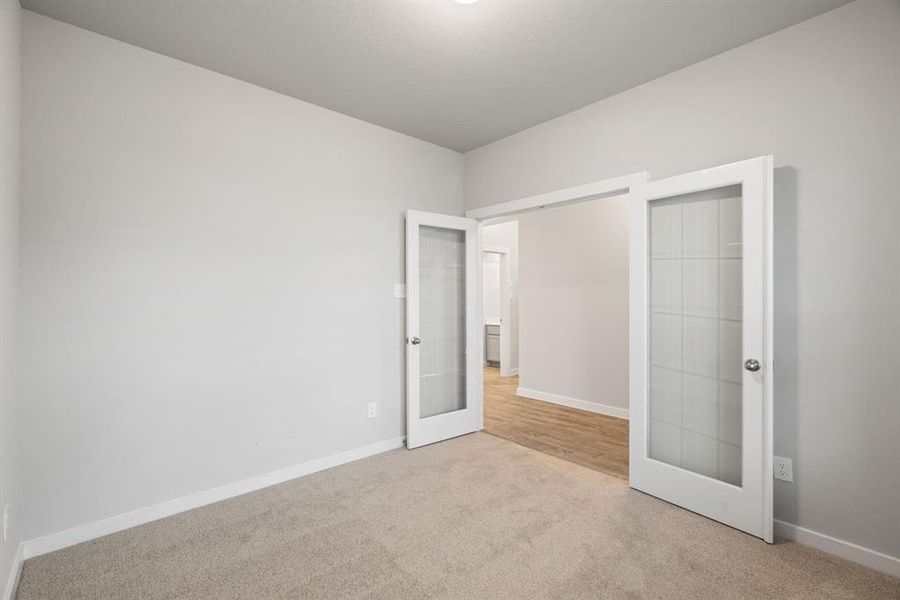 Another view of the office adorned with French doors. Sample photo of completed home with similar floor plan. As-built interior colors and selections may vary.