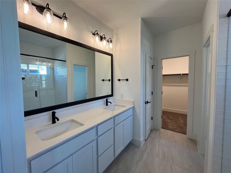 Master with double vanity, framed mirror, Black finishes. Large walk in closet