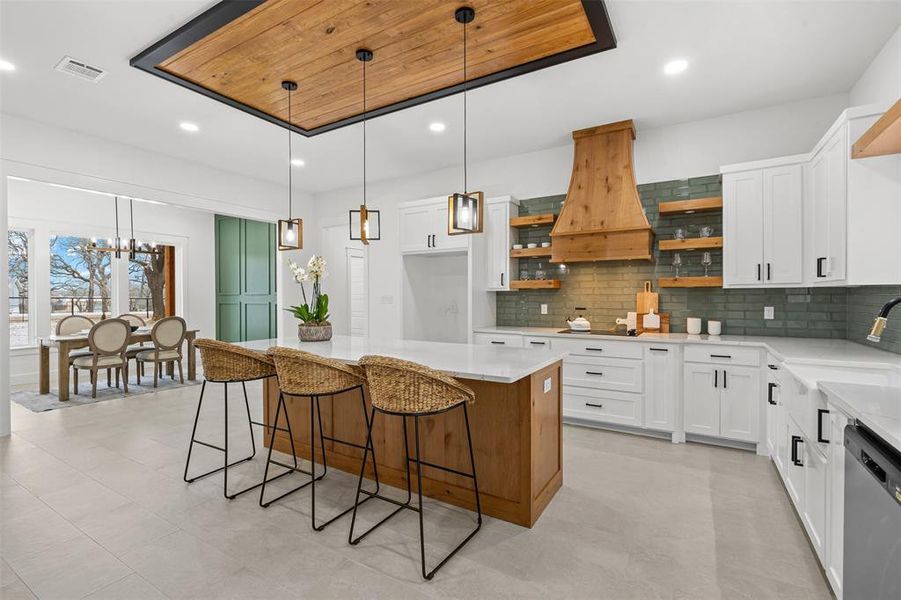 Kitchen featuring a center island, pendant lighting, white cabinetry, and open shelves