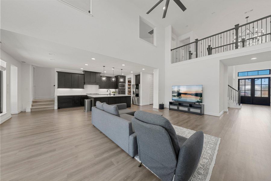 Living area featuring light wood-type flooring, baseboards, and stairway