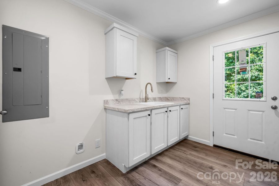 Laundry room with sink and cabinets for storage