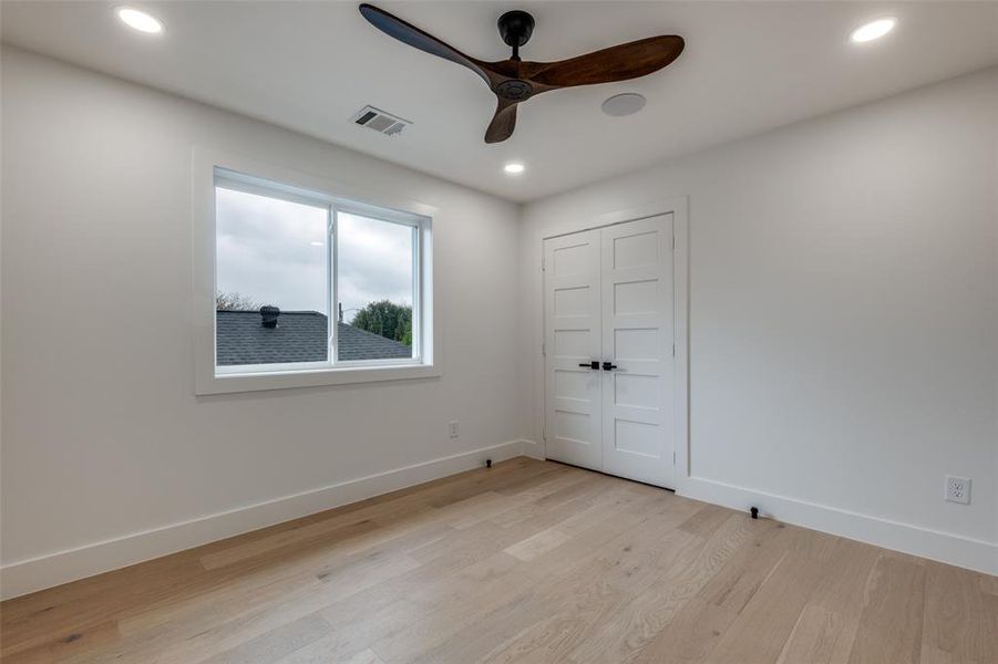 Unfurnished bedroom featuring light wood-style flooring, recessed lighting, ceiling fan, and a closet