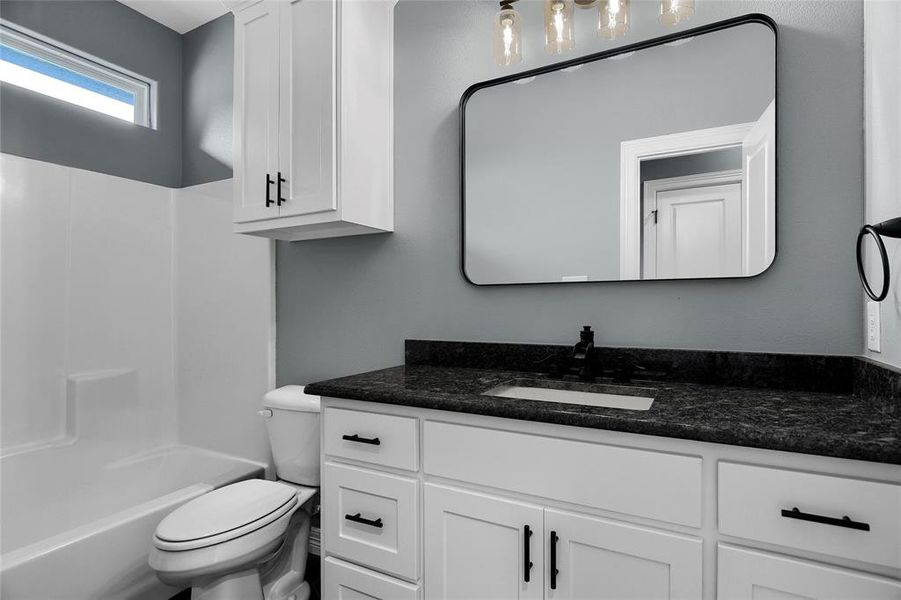 Full bathroom featuring bathing tub / shower combination, toilet, and large vanity