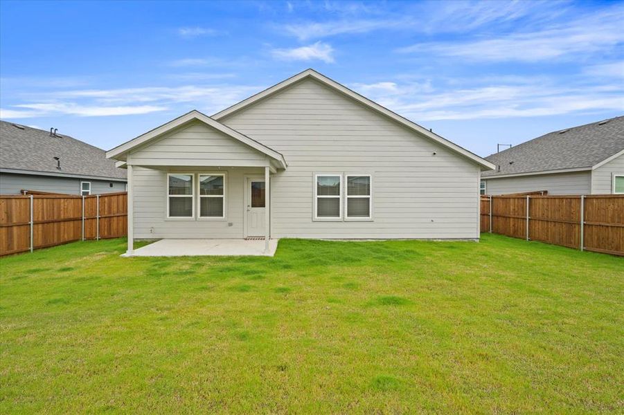 Back of house with a patio area and a yard