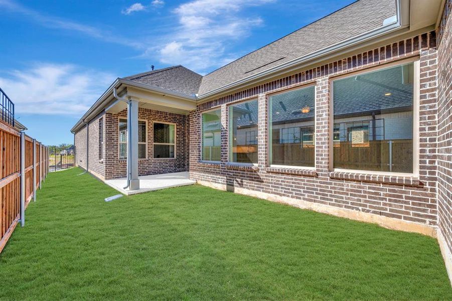 Rear view of property featuring a patio area, brick siding, and a shingled roof
