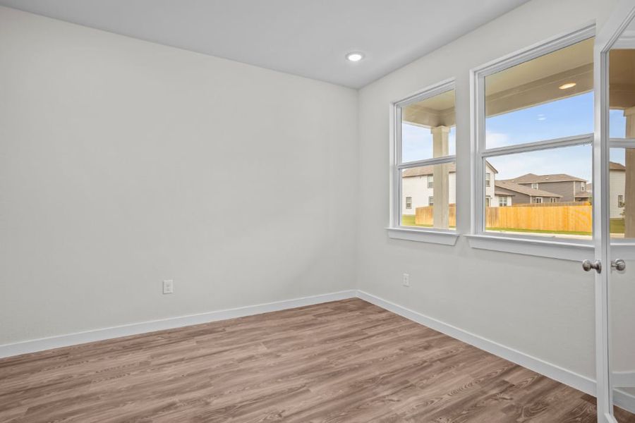 A room with a wood floor and a window with a wood floor. A room with a wood floor and a window with a wood floor.