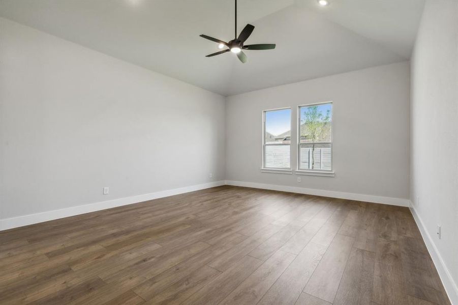 Spare room with ceiling fan, dark wood-type flooring, and high vaulted ceiling