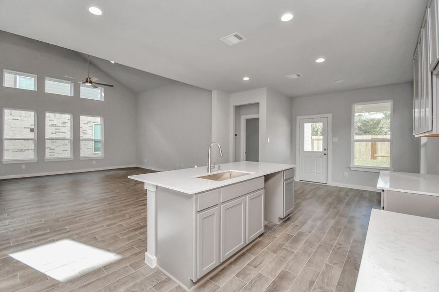Discover another view of the kitchen that opens up to the expansive family room, creating a perfect hub for gatherings. Sample photo of completed home with similar floor plan. Actual colors and selections may vary. Discover another view of the kitchen that opens up to the expansive family room, creating a perfect hub for gatherings. Sample photo of completed home with similar floor plan. Actual colors and selections may vary.
