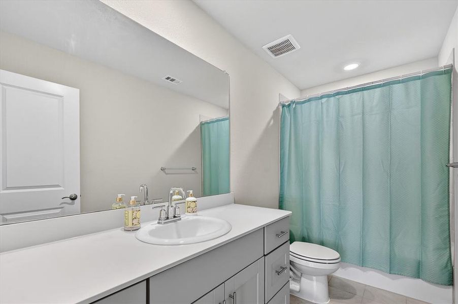 Full bath with vanity, light tile patterned floors, and shower / bathtub combination with curtain
