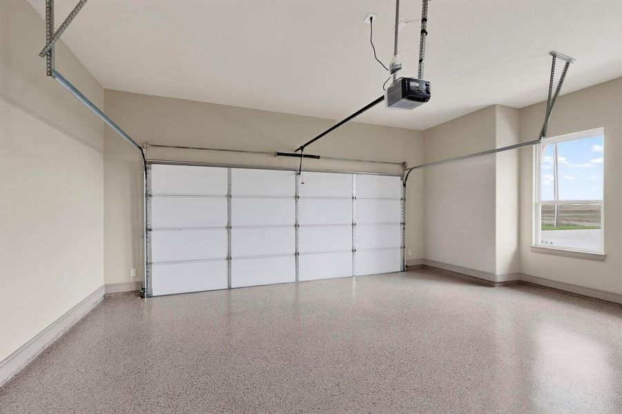 Garage with a garage door opener and baseboards Garage with a garage door opener and baseboards