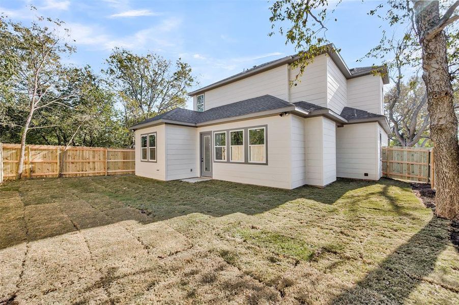 Back of house with roof with shingles and a fenced backyard