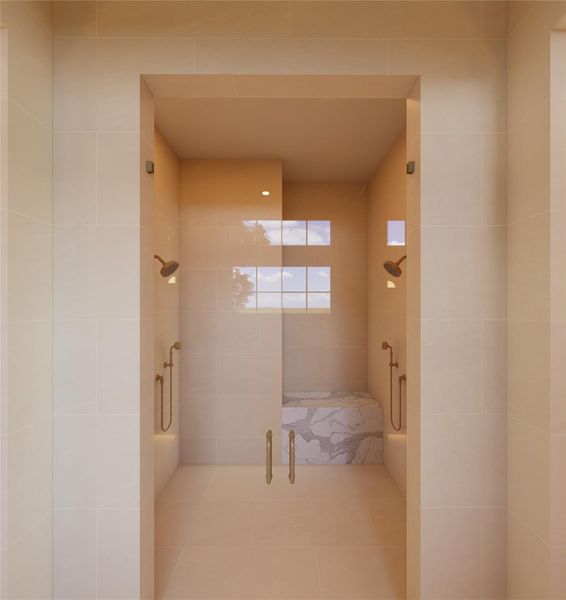A serene retreat designed with symmetry and intention, this walk-in shower offers a spa-like experience at home. Soft, tonal stone surrounds dual fixtures and a sculptural bench, while natural light filters in to create a calming, restorative atmosphere.
