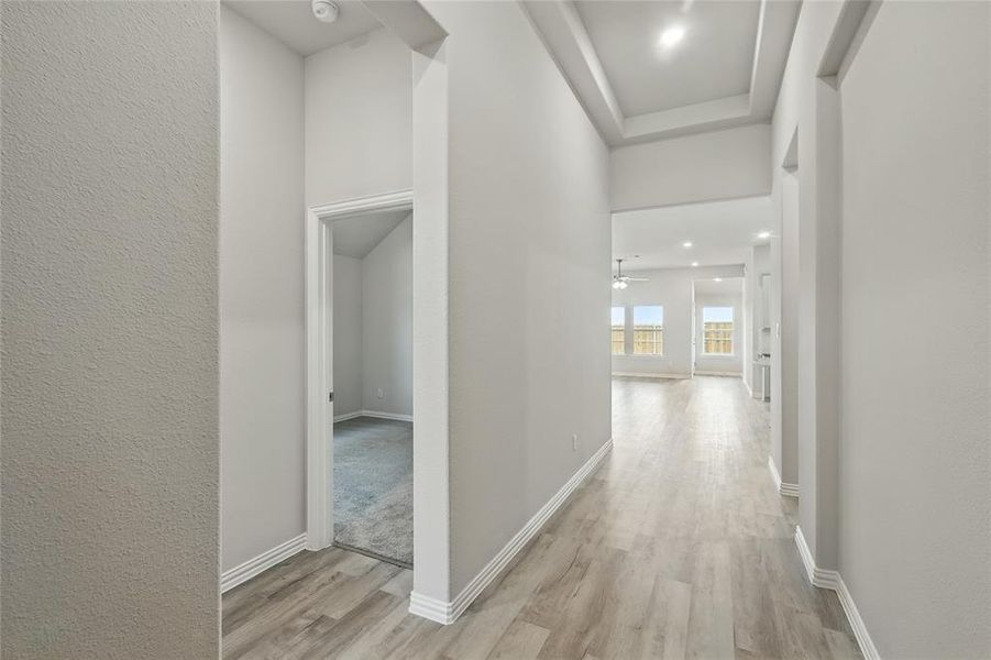 Hallway featuring a textured wall, light wood finished floors, and recessed lighting Hallway featuring a textured wall, light wood finished floors, and recessed lighting