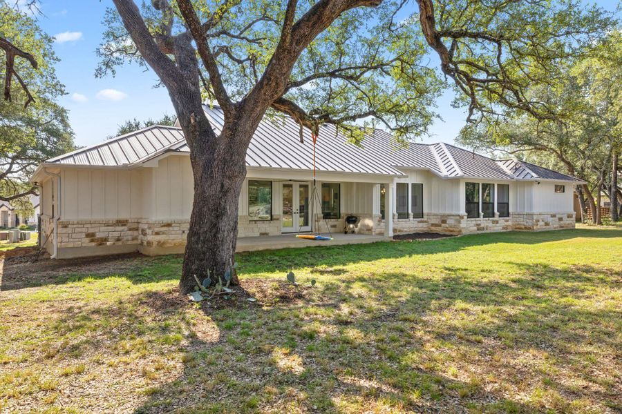 Back of house featuring stone siding, french doors, a patio, and board and batten siding