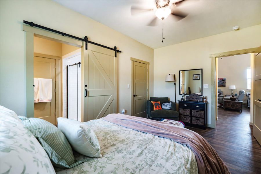 Primary bedroom featuring LVP flooring, barn door and ensuite bath Primary bedroom featuring LVP flooring, barn door and ensuite bath