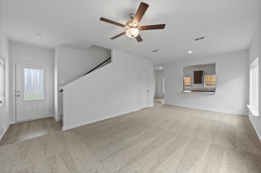 Living room featuring ceiling fan and light colored carpet