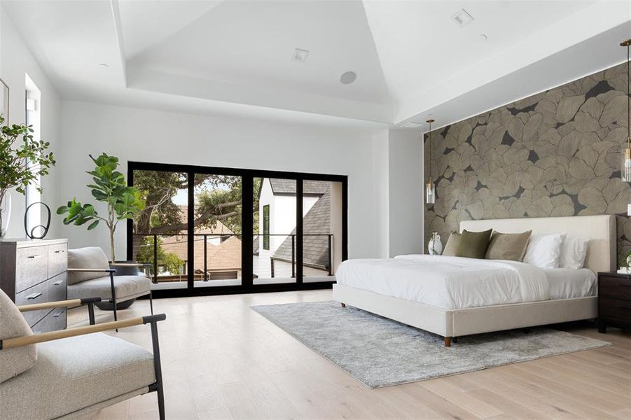 Bedroom featuring access to exterior, multiple windows, light hardwood / wood-style flooring, and lofted ceiling