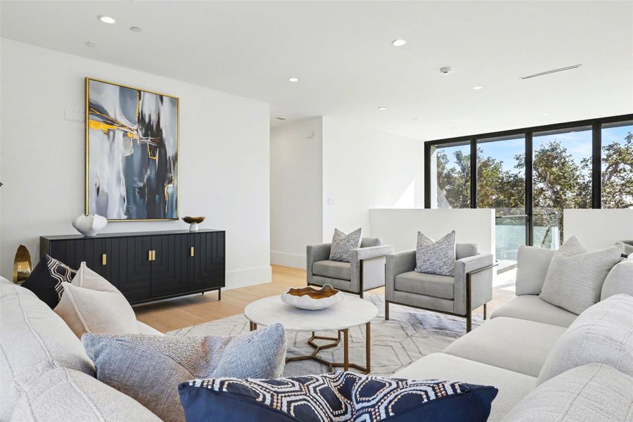 Living area featuring expansive windows, light wood finished floors, and recessed lighting