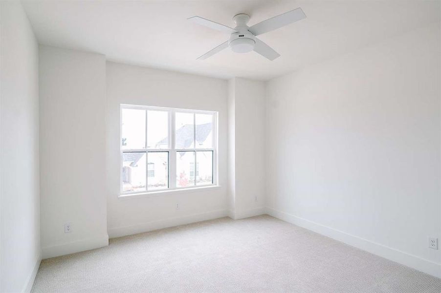 Carpeted spare room with ceiling fan