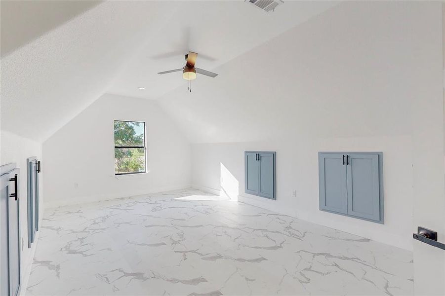 Additional living space featuring light tile patterned floors, lofted ceiling, and ceiling fan