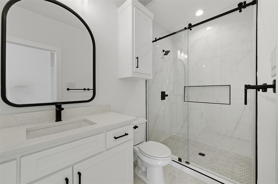 Full bath featuring a marble finish shower, vanity, recessed lighting, and light tile patterned flooring