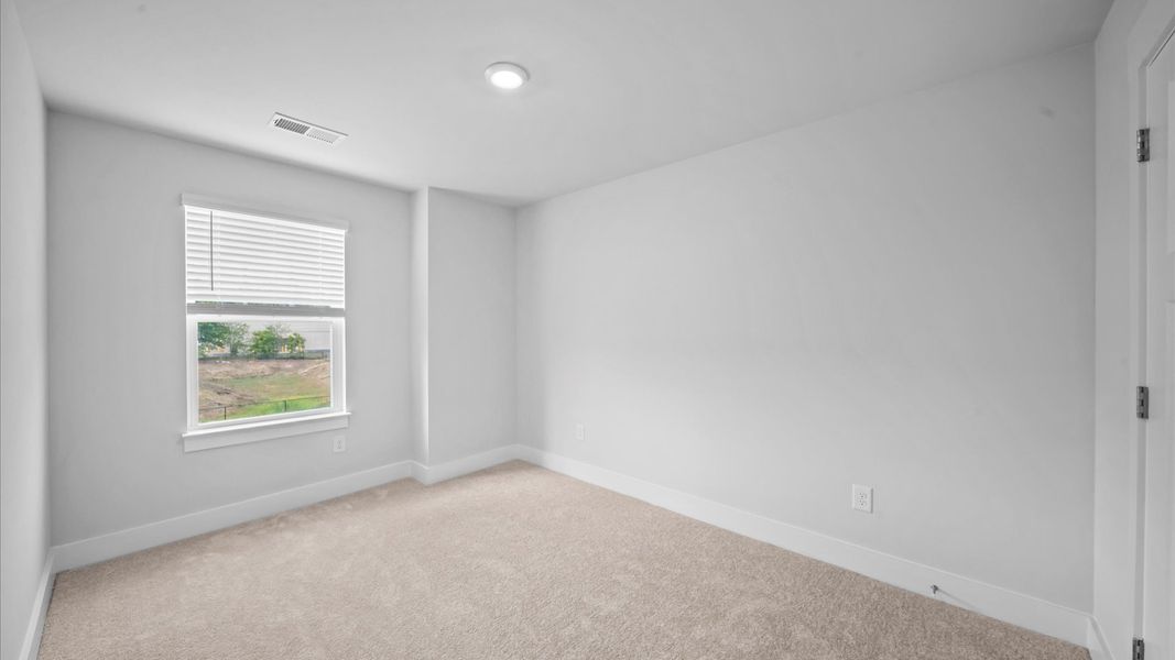 Bedroom with plush carpet, a walk-in closet, and large windows for abundant natural light at Saluda Crossing in Piedmont, SC