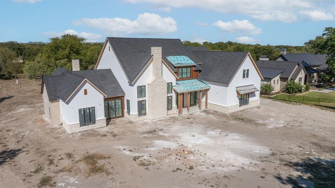 View of front facade featuring a chimney, stucco siding, stone siding, and a shingled roof View of front facade featuring a chimney, stucco siding, stone siding, and a shingled roof