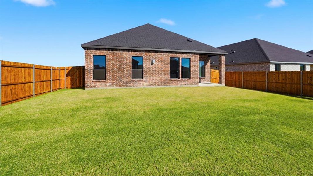 Back of property featuring brick siding, a patio, a shingled roof, and a fenced backyard