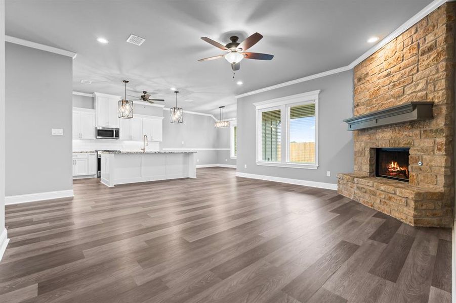 Living room with a fireplace, ceiling fan, and recessed lighting Living room with a fireplace, ceiling fan, and recessed lighting
